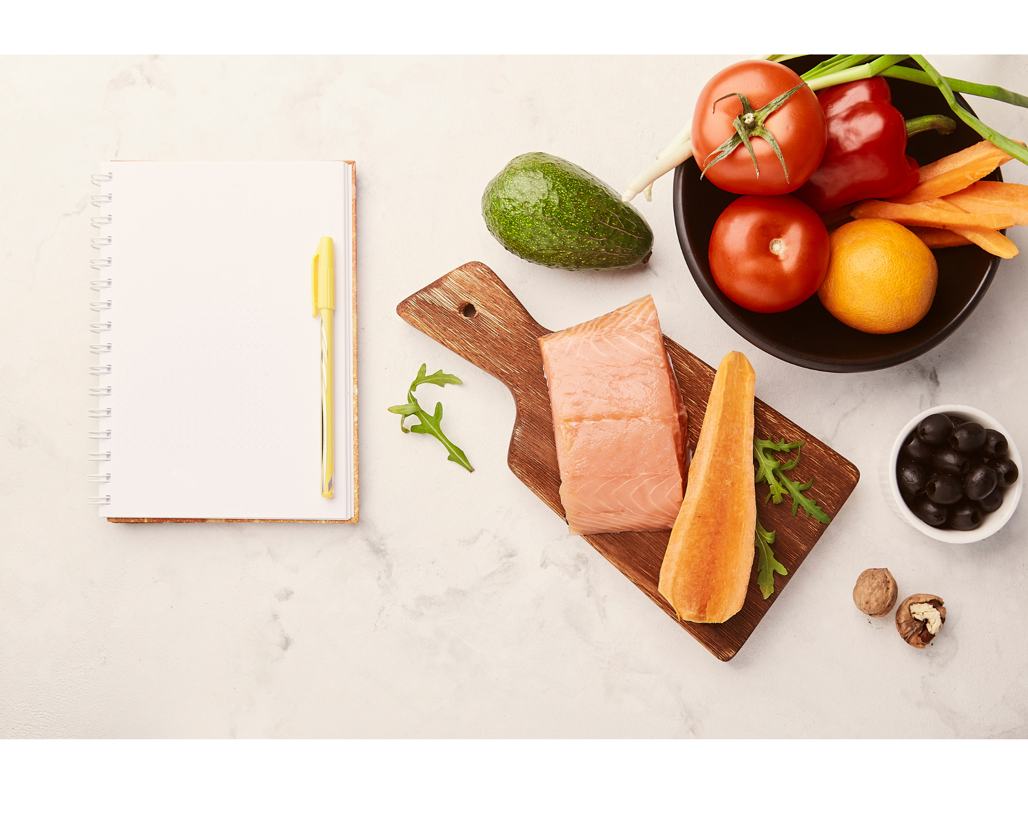 Healthy meal planning setup with salmon, vegetables, and notebook for balanced diet and nutrition