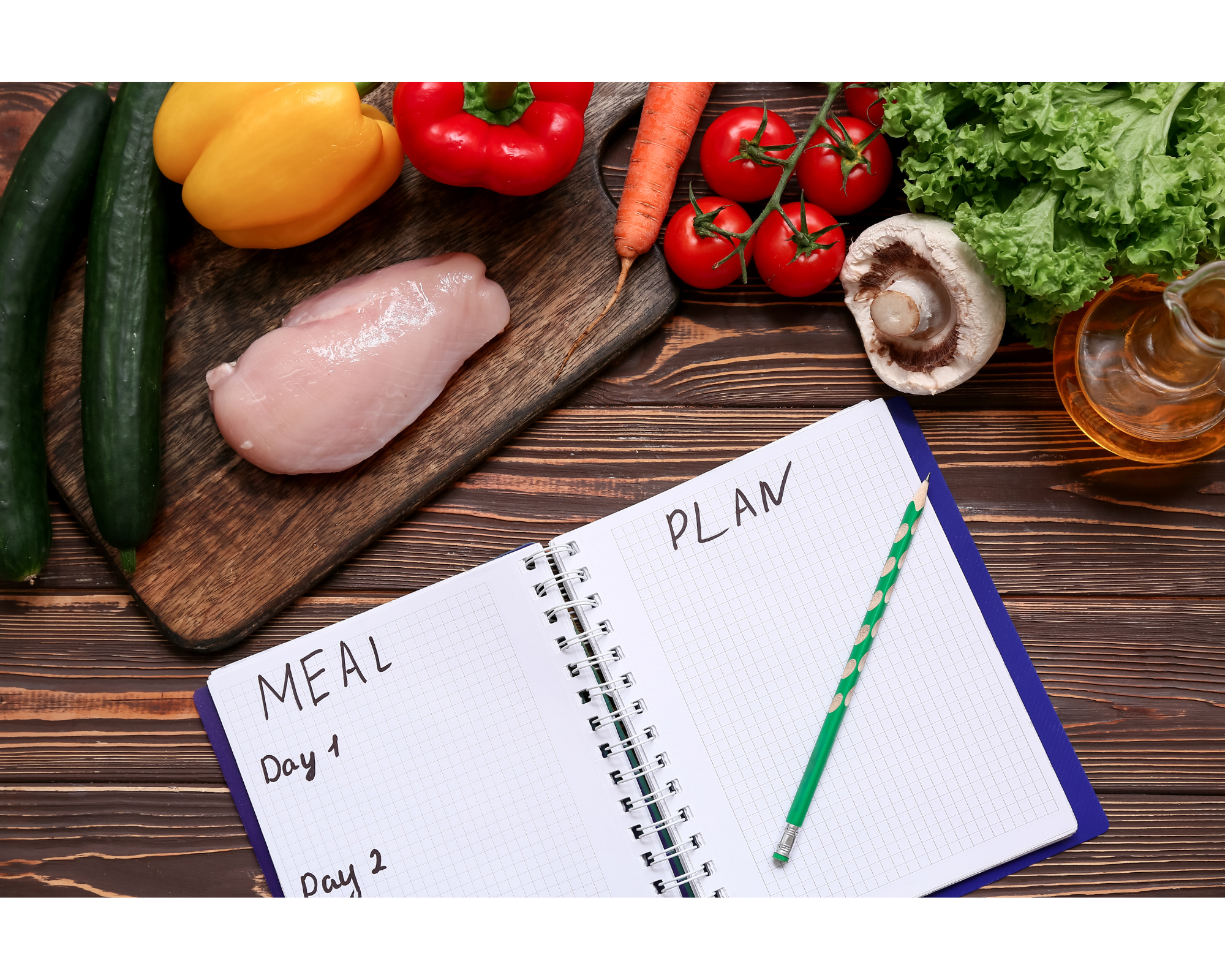 Meal planning notebook with fresh ingredients including chicken and vegetables for structured diet and nutrition planning